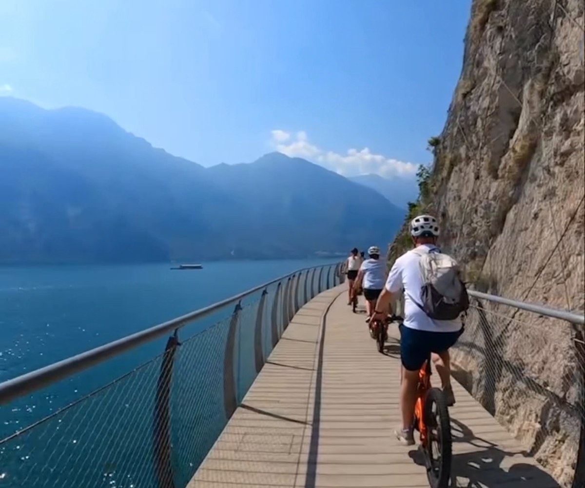 Cyclists on the suspended Ciclovia di Limone above Lake Garda